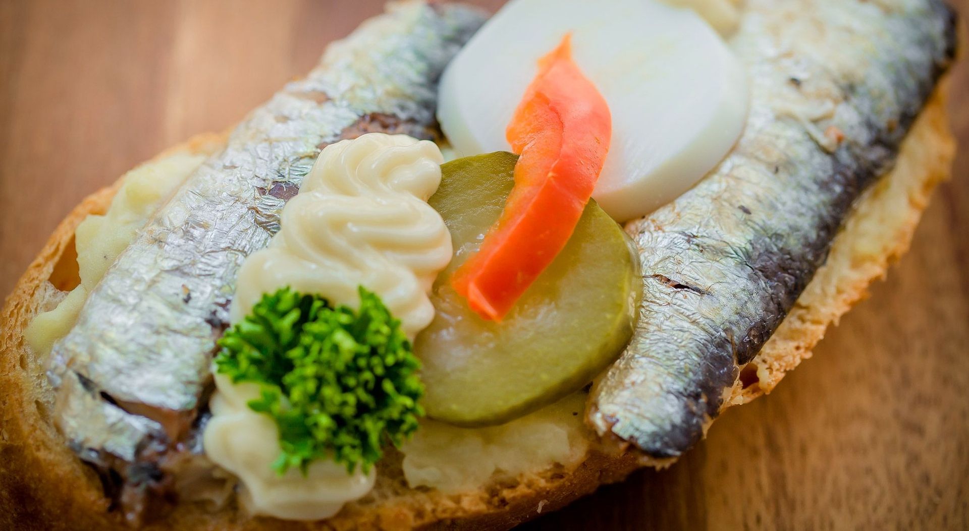 Ein Sandwich mit Garnelen, Gurken und einem Ei, appetitlich angerichtet auf einem weißen Teller.